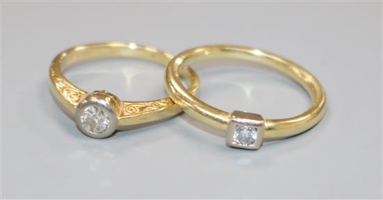 Two yellow metal and solitaire diamond rings.